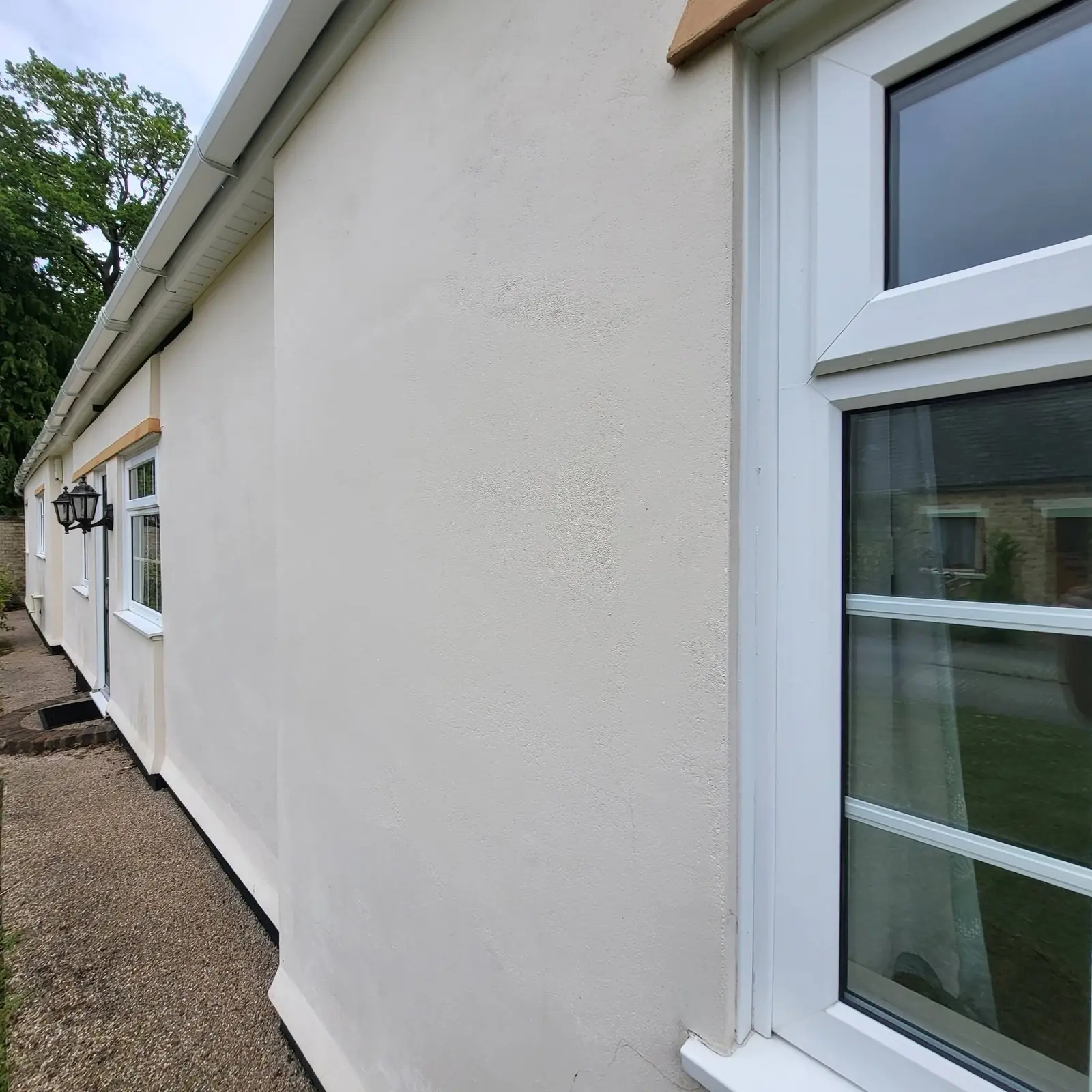 Clean white uPVC fascias, soffits and guttering running along the eaves of a rendered bungalow